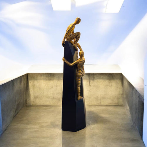 Human Assisting Another in Climbing Decorative Artefact