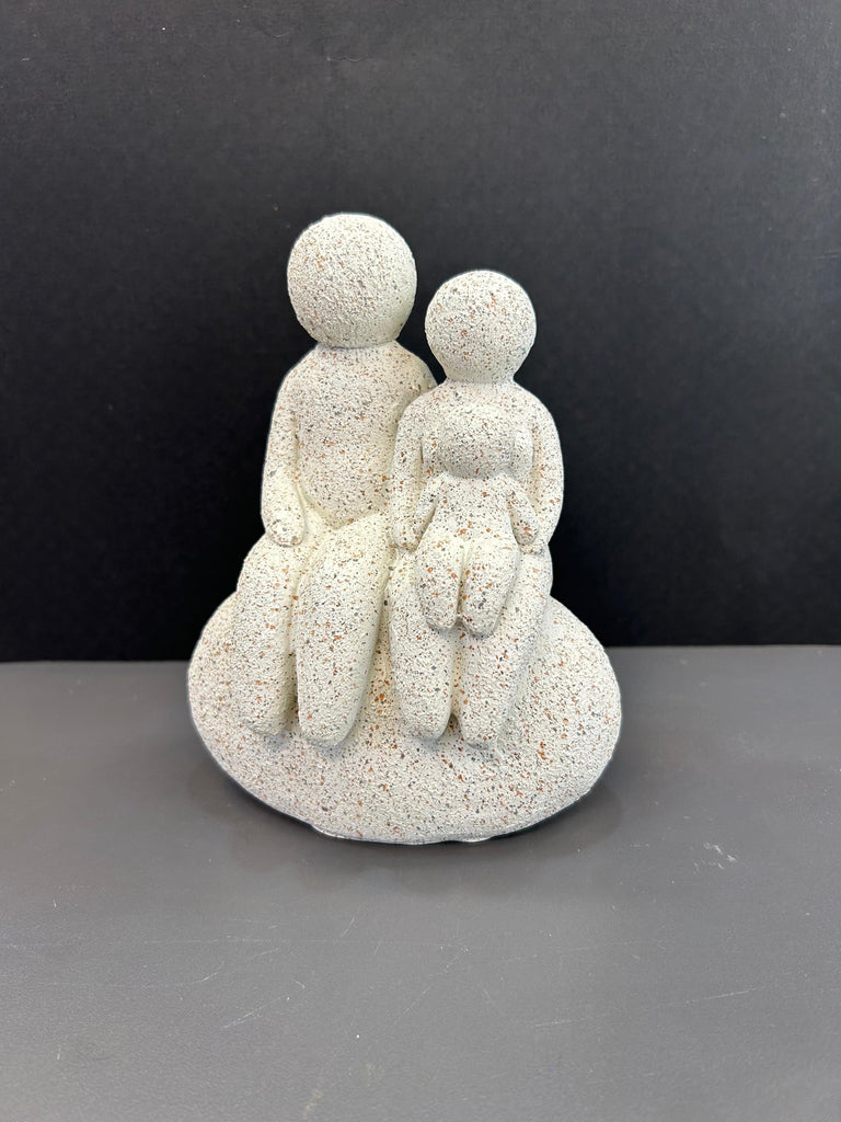 White Colour Artefact of Family Seated on a Rock