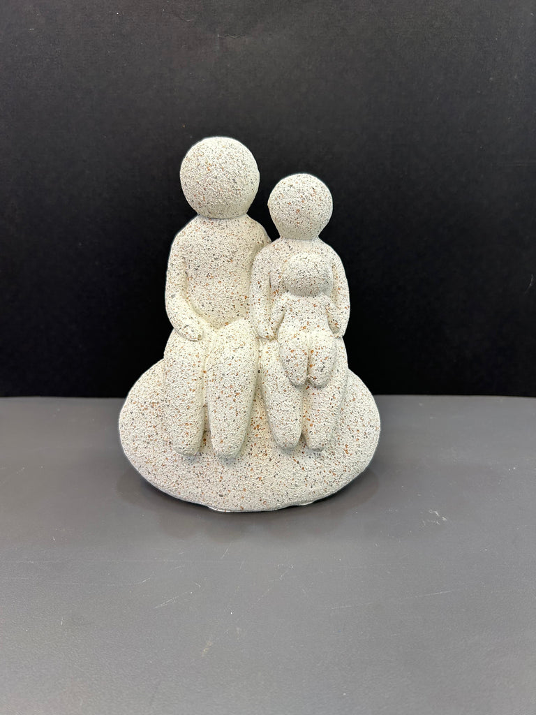 White Colour Artefact of Family Seated on a Rock